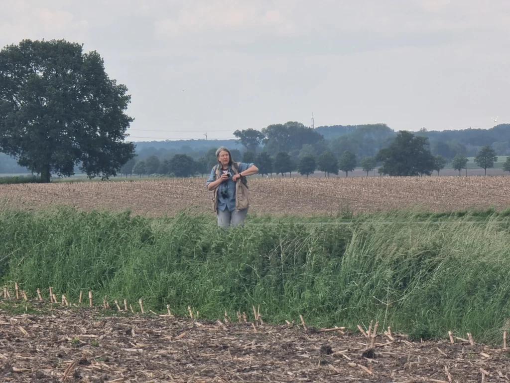 Zu sehen ist eine Person, die auf einem Feld steht.