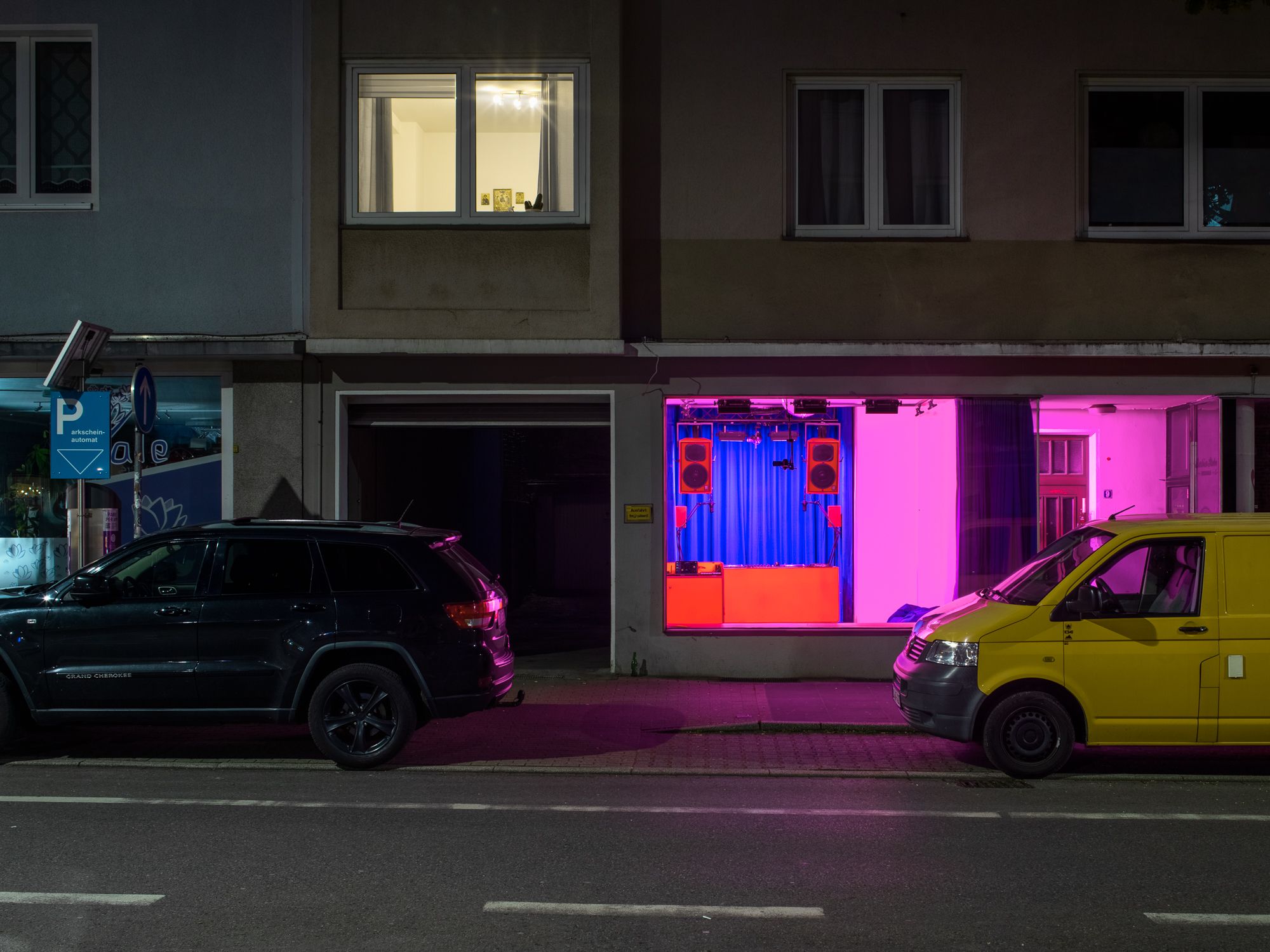 Das Bild zeigt den CC-Space von der Straße aus. Er ist rosa-rot beleuchtet.