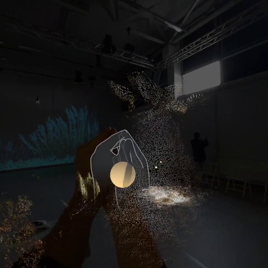 Blick auf Bühne durch VR-Headset; Hände und ein Tier werden auf das Bild projiziert