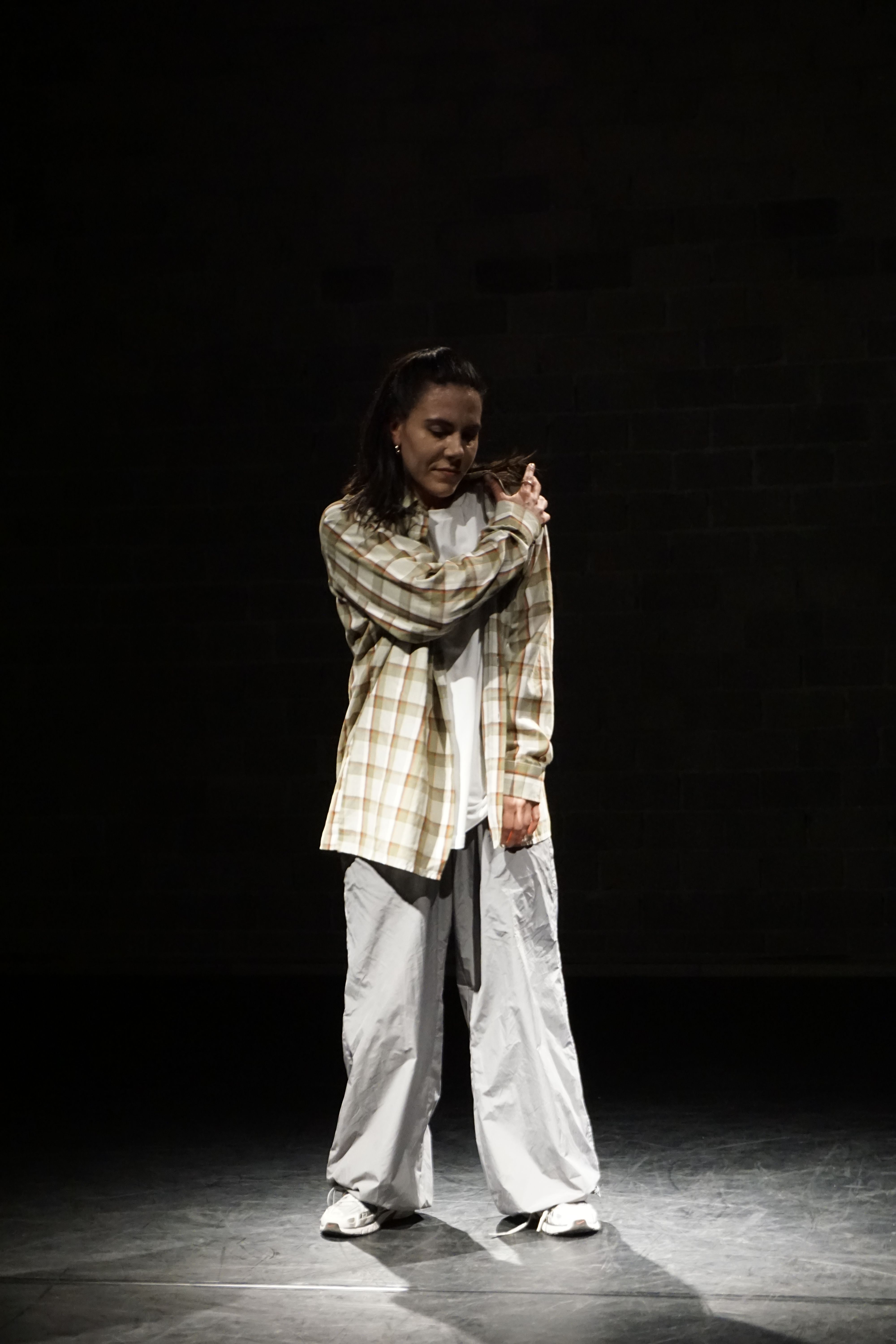 Person dancing onstage under spotlight 