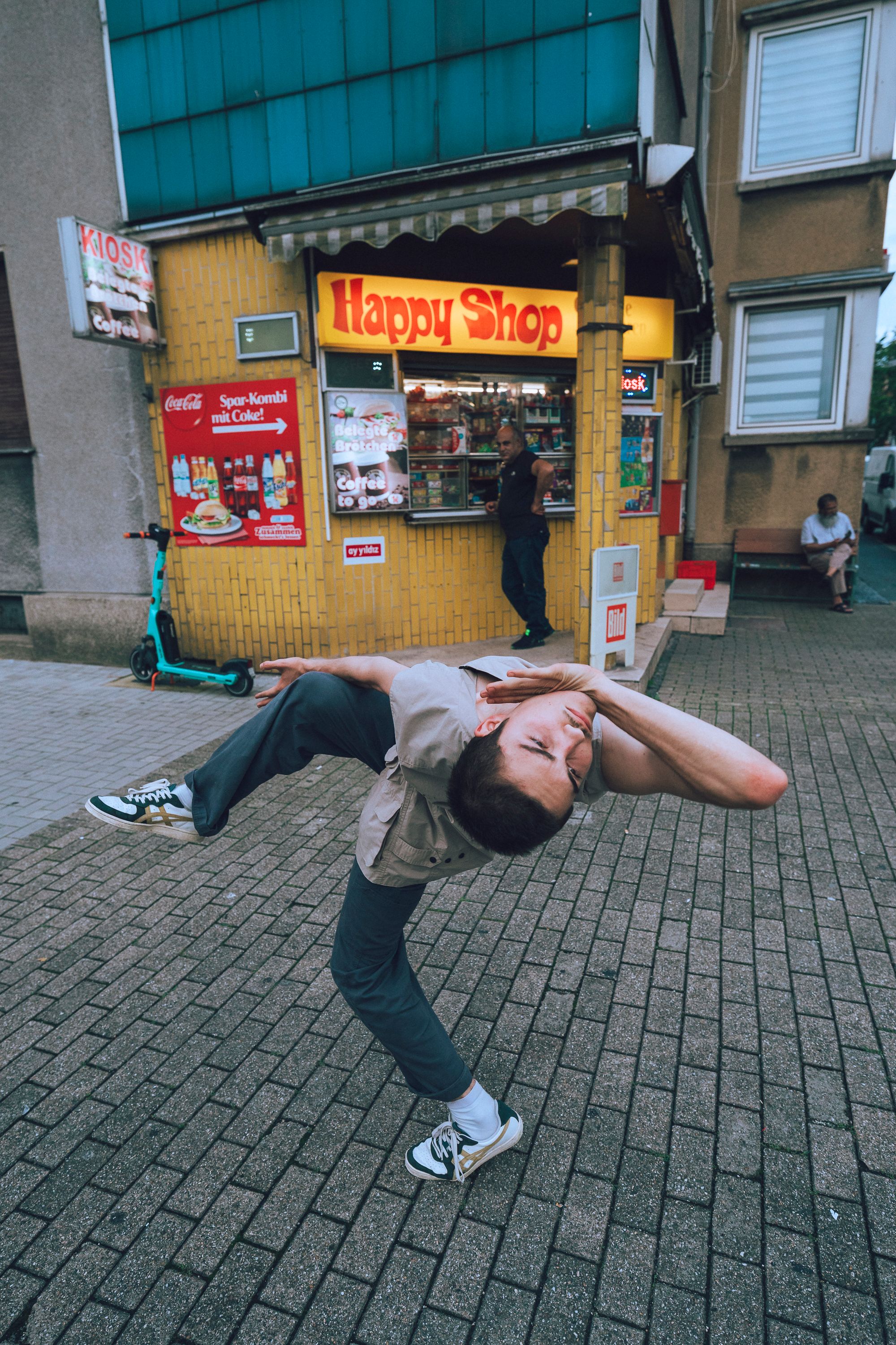 A dancer can be seen in front of a shop.