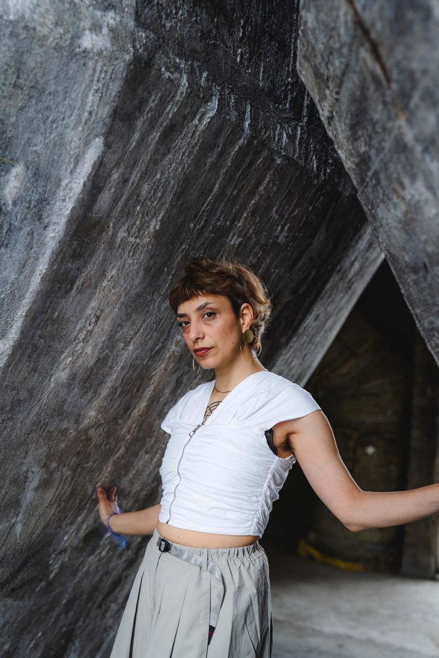 Profile of a person standing between two concrete walls.