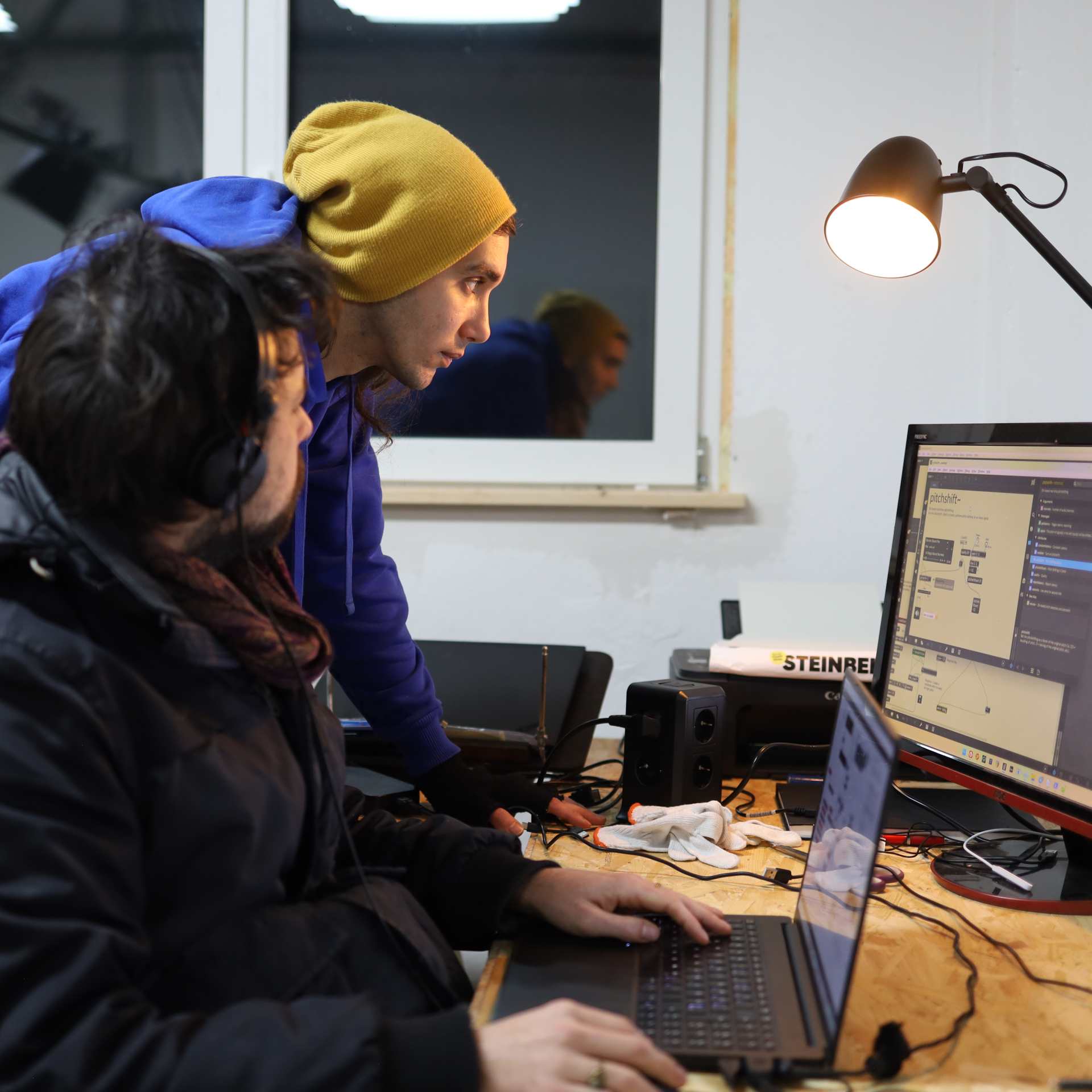 two people sitting in front of screens and working creatively