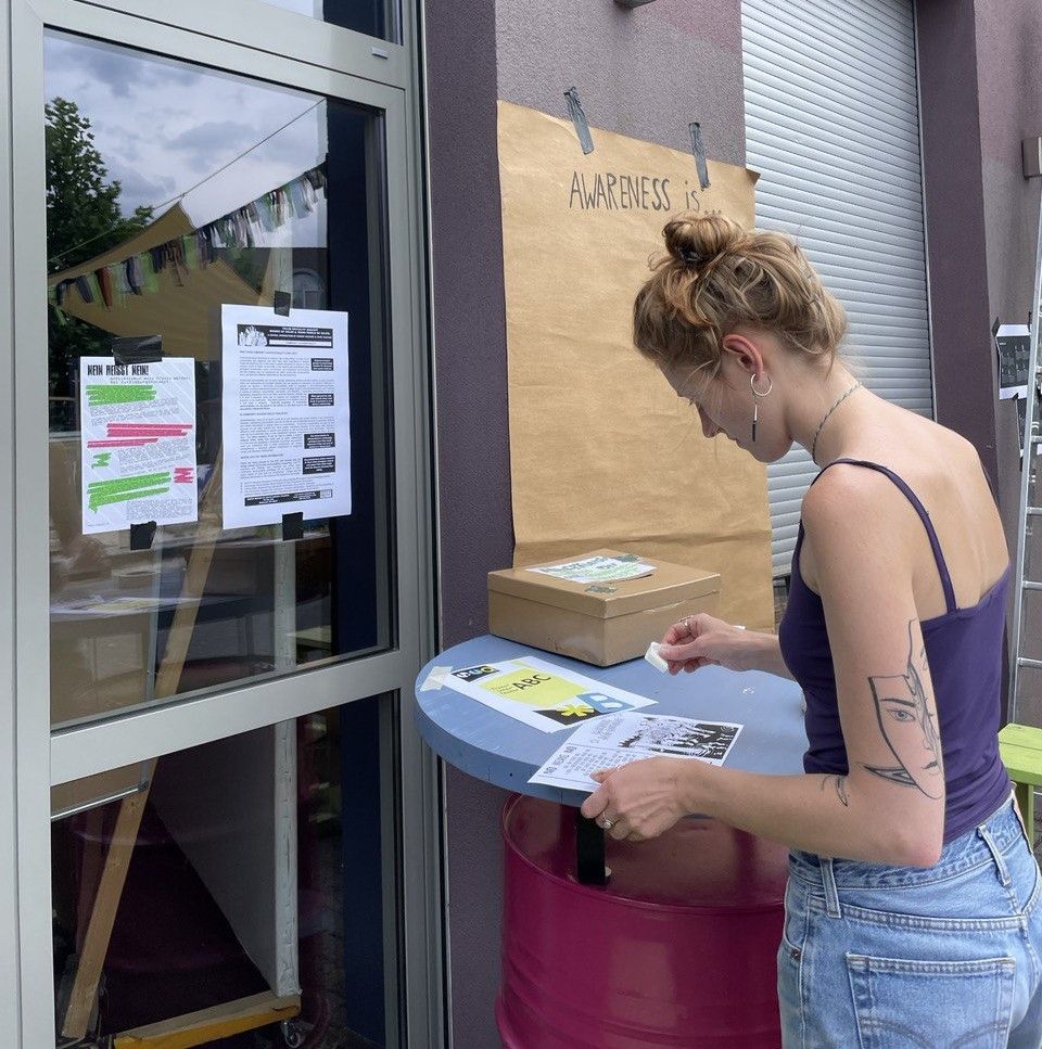One person stands with their back to the camera. They are working on the external perception of the awareness concept: sticking notes on the wall.