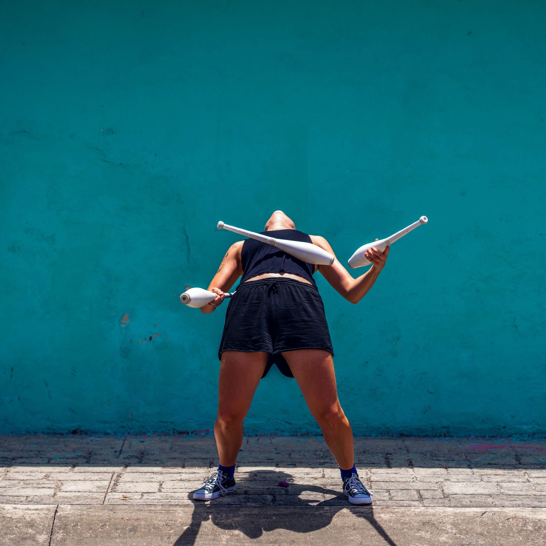 Juggler leaning back and balancing a club on her stomach