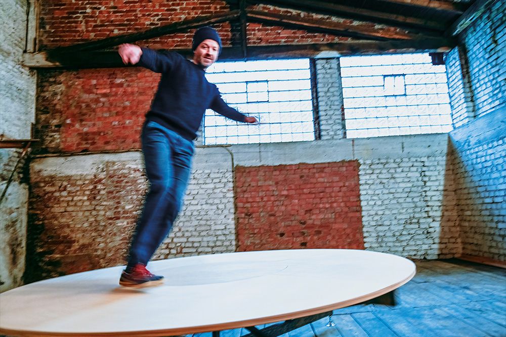 You can see a person on a round disk. The person is trying to balance themselves on the disk.