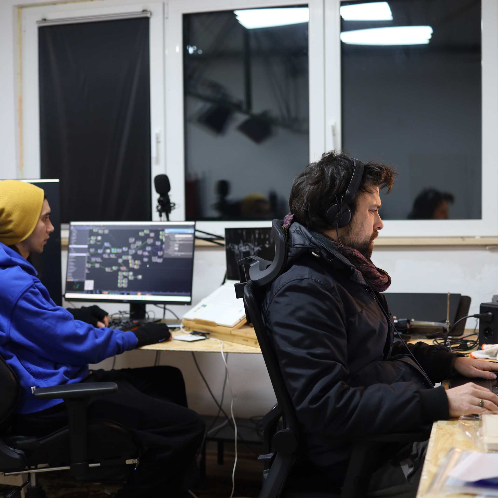 two people sitting in front of screens and working creatively