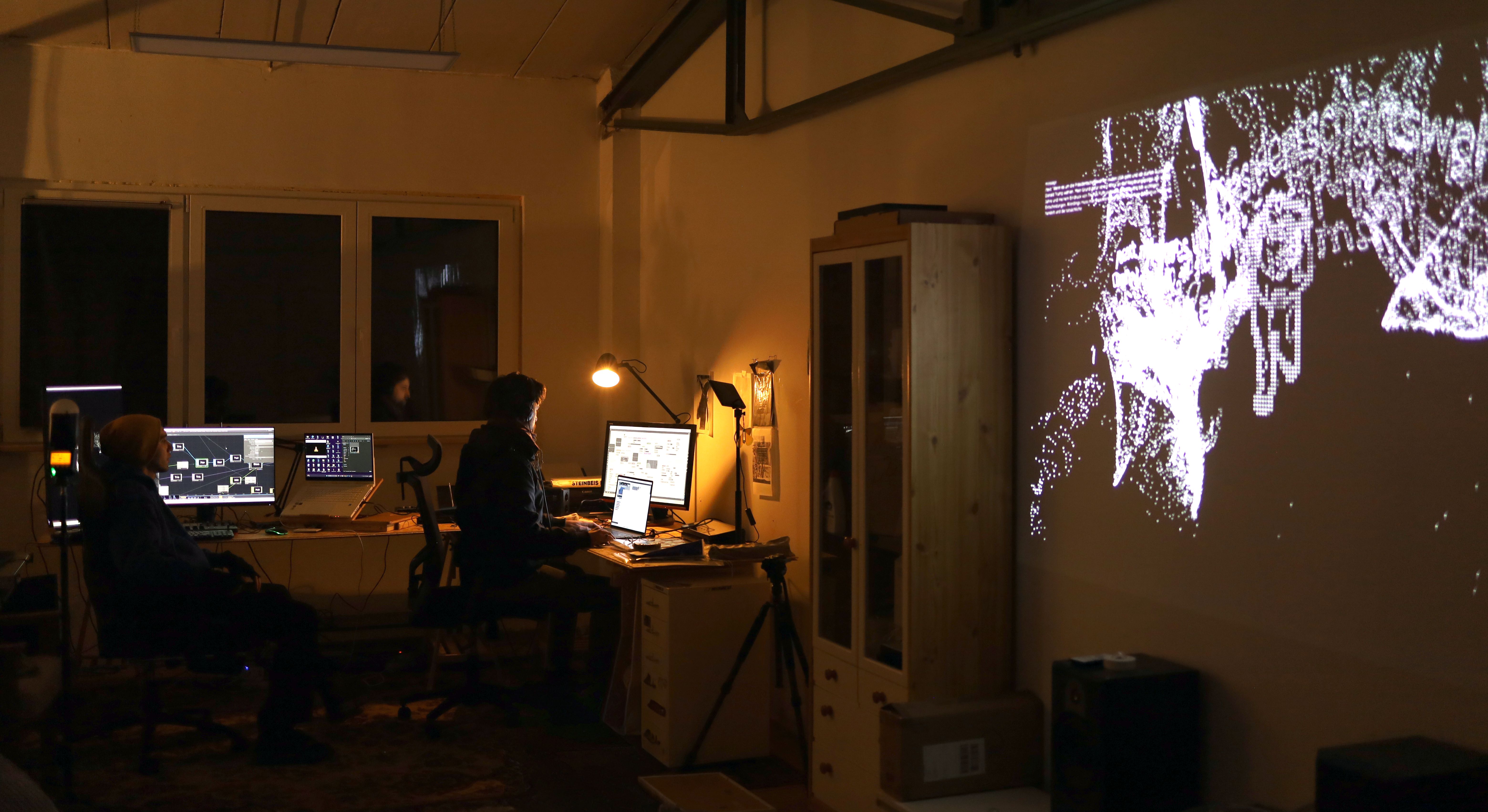 two people sitting in front of screens and working creatively