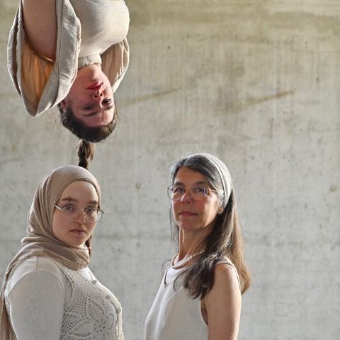three acrobats looking into the camera