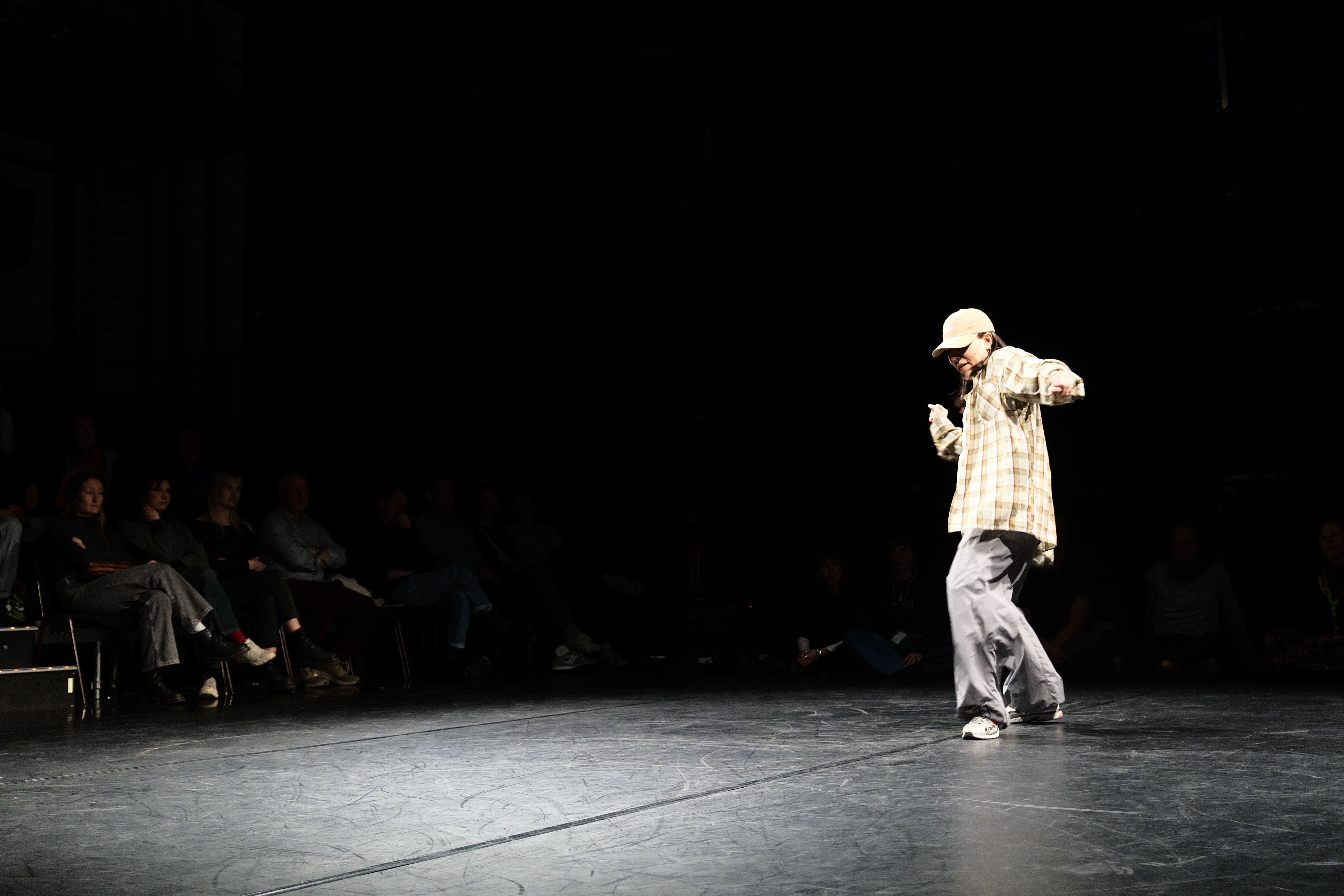 Person Dancing under spotlight onstage with view of audience 