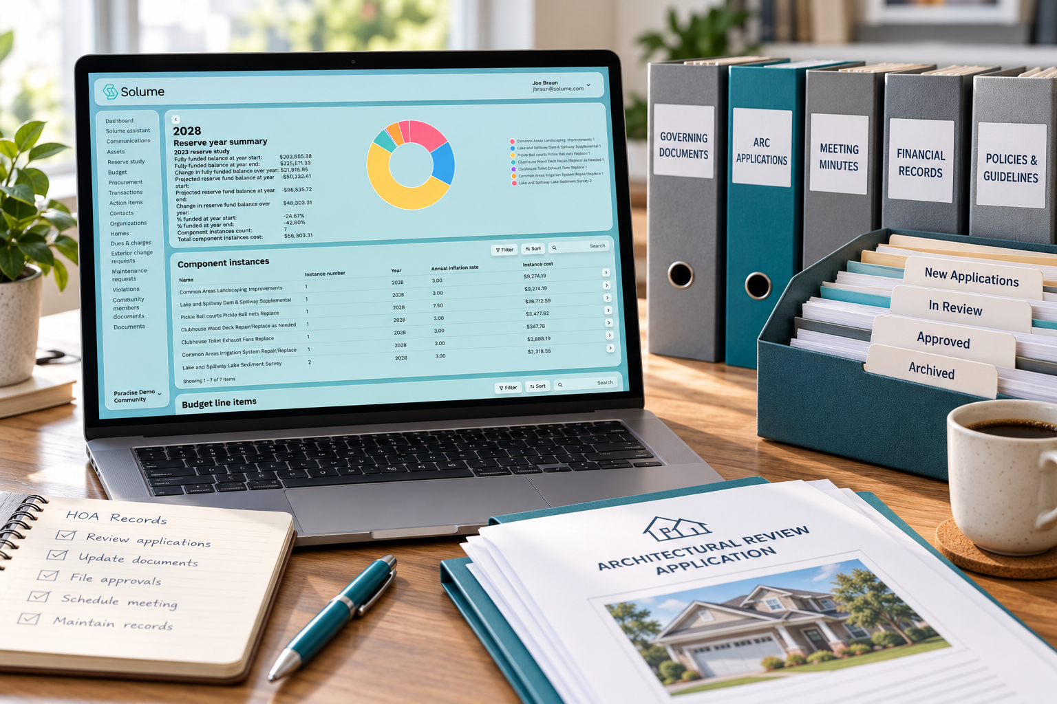 Solume HOA records dashboard displayed on a laptop beside neatly labeled binders, archived documents, and an architectural review application on a desk.