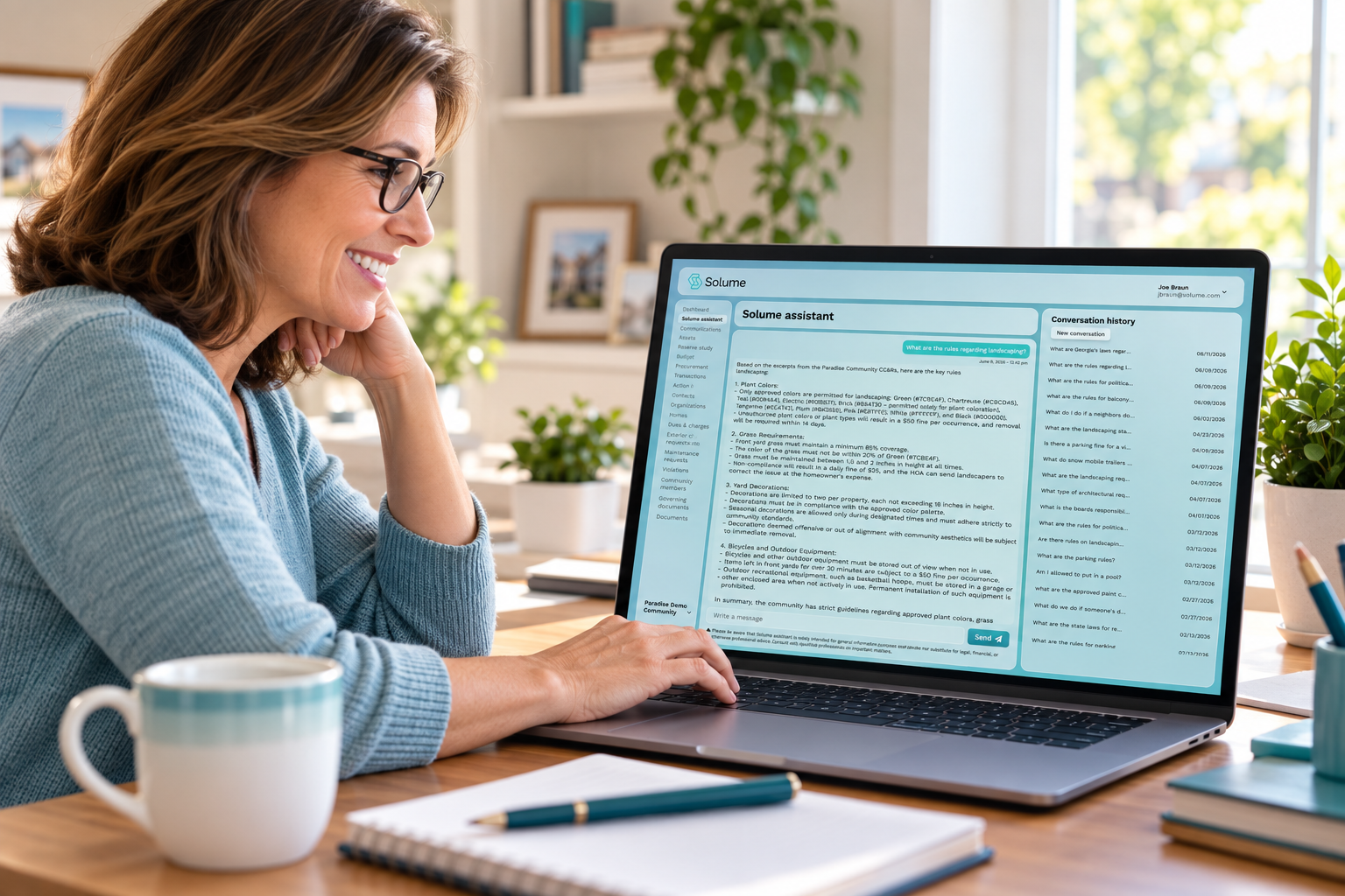 Volunteer board member using a laptop displaying the Solume assistant dashboard in a bright home office.