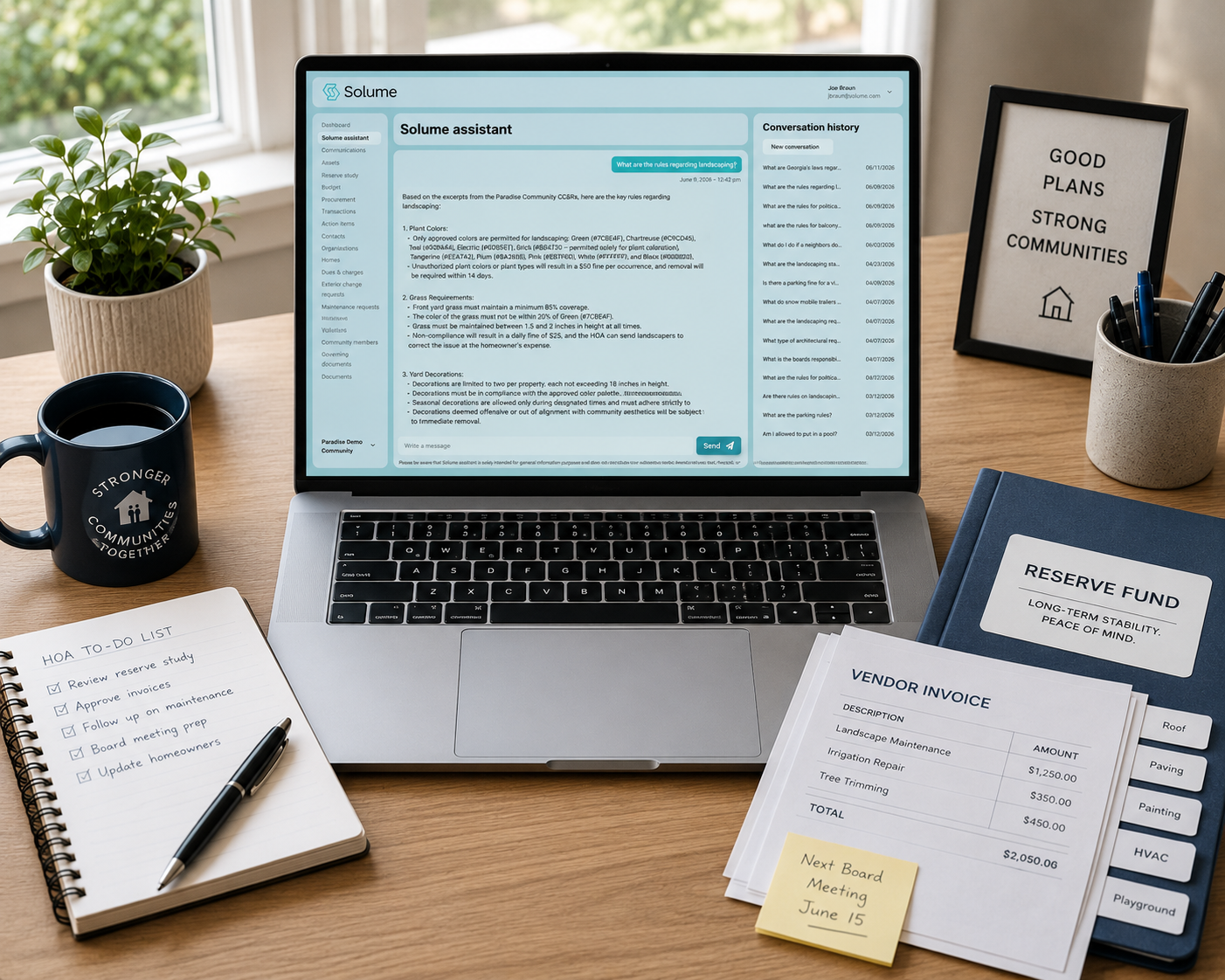 An organized home office workspace with a laptop displaying the Solume Assistant interface, surrounded by a reserve fund binder, vendor invoices, a notepad, and office essentials, illustrating how HOA volunteers can efficiently manage community documents and administrative tasks.