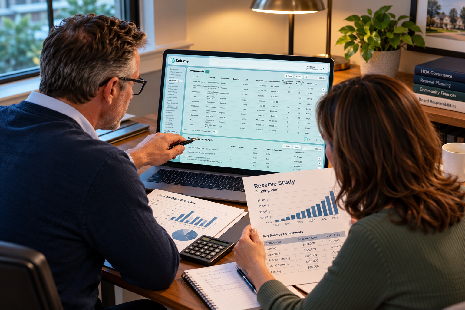 HOA board members reviewing a reserve study and community planning data on a laptop using Solume’s reserve study platform.