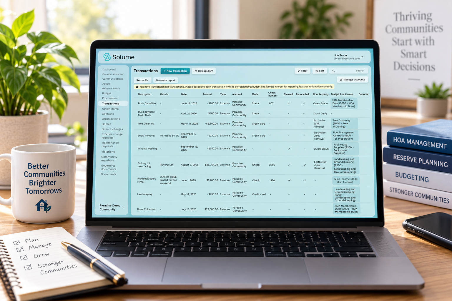 Solume’s HOA transaction management dashboard with financial records, transaction details, and budget line items on a tidy home-office desk.