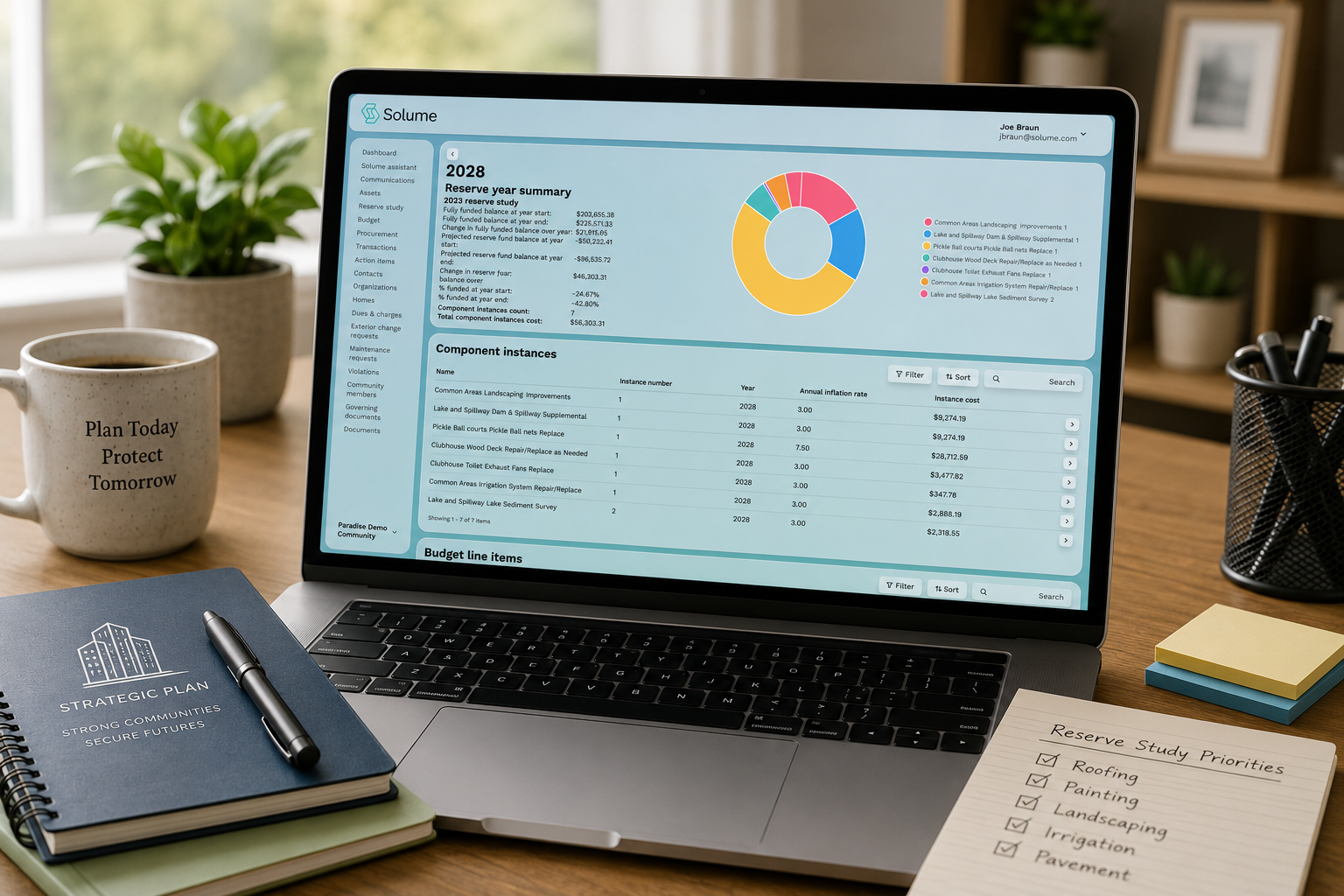 Laptop on a bright home office desk displaying the Solume reserve study dashboard with a reserve year summary, funding chart, and component cost table, surrounded by office supplies in a clean, modern workspace.