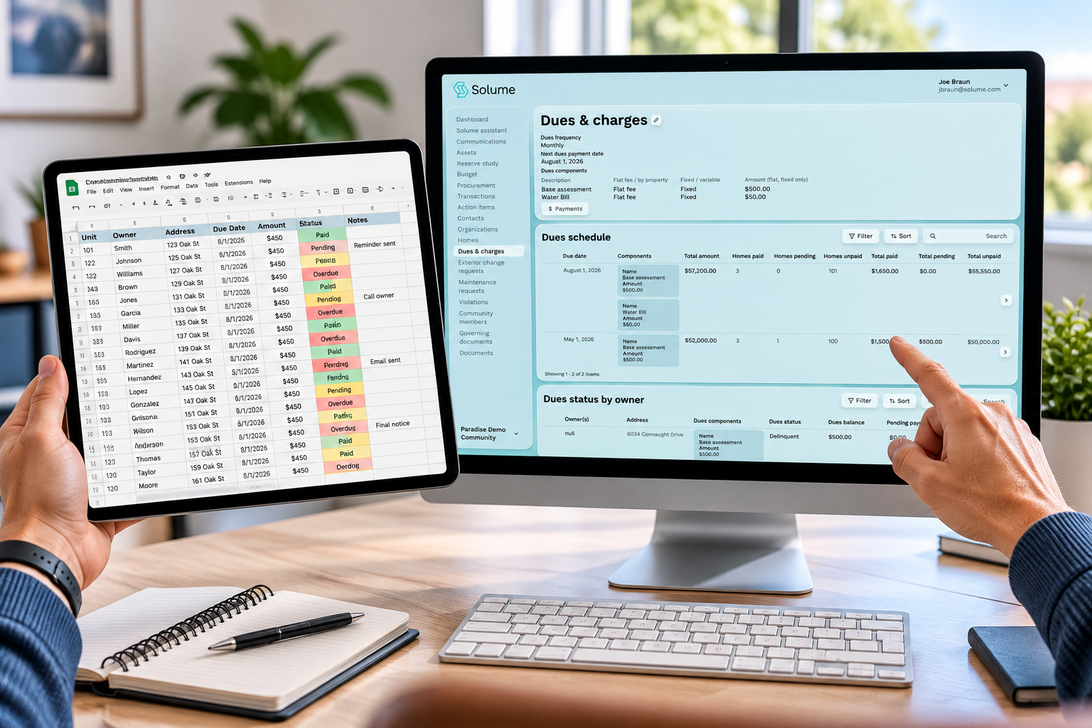 Hands comparing a spreadsheet of HOA dues on a tablet with Solume’s Dues & Charges dashboard on a desktop monitor, displaying payment schedules, dues balances, and payment statuses.