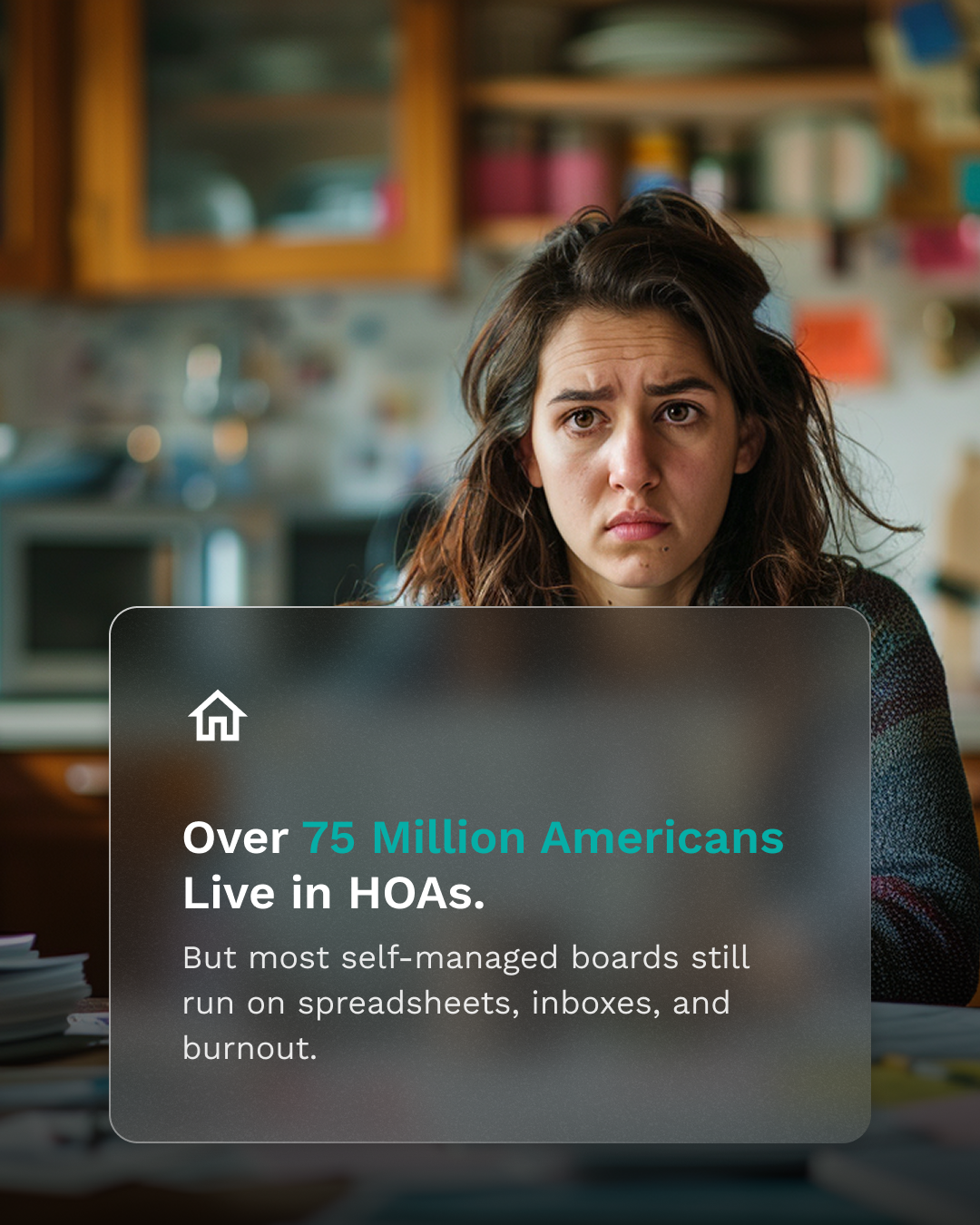 A frustrated woman sits at a cluttered kitchen table with a laptop, surrounded by paperwork and sticky notes. Her expression shows fatigue and overwhelm, representing a volunteer HOA board member struggling to manage community responsibilities without proper tools.