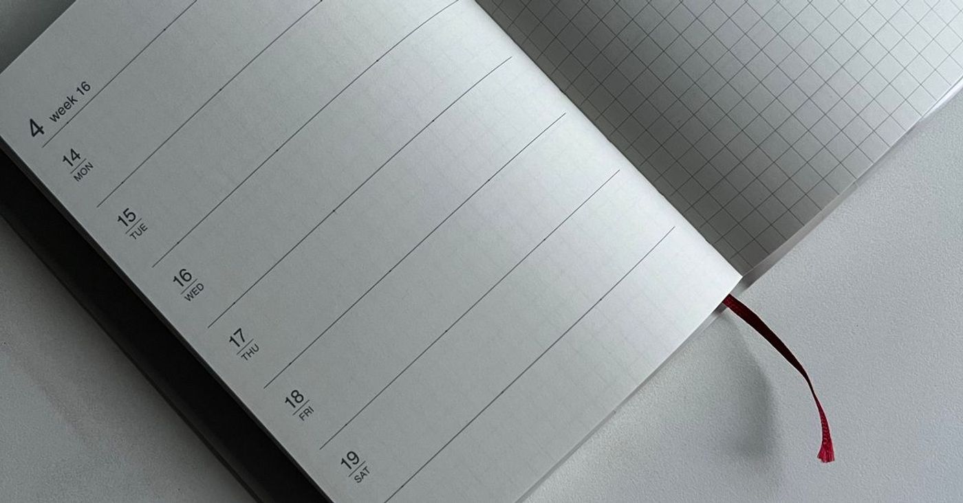 An open planner with calendar and squared pages on a neutral surface.