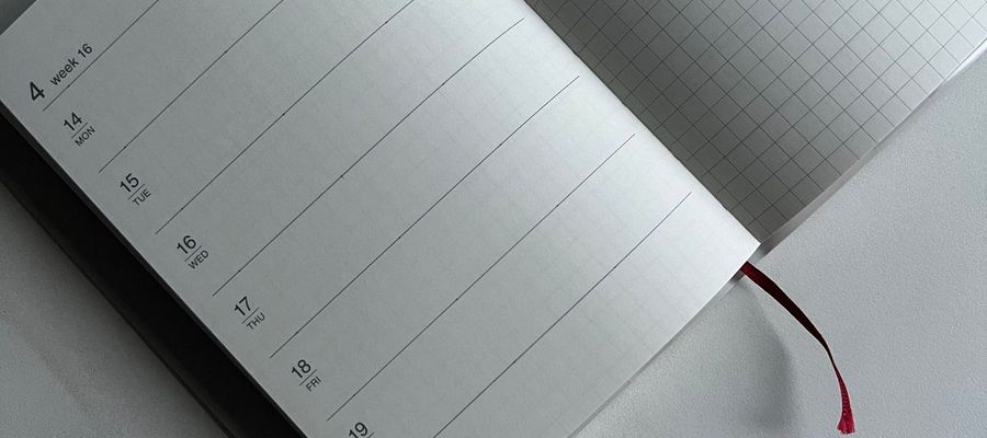 An open planner with calendar and squared pages on a neutral surface.