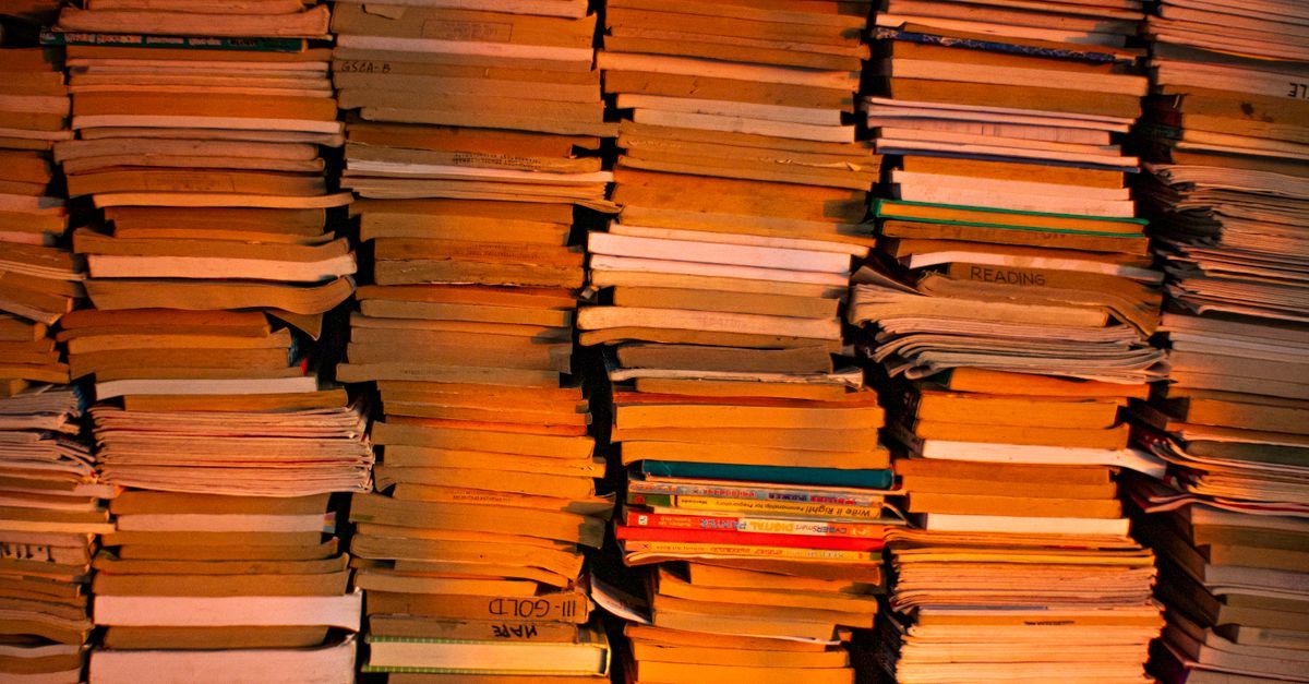 Stacks of books in a warmly lit library or bookstore.