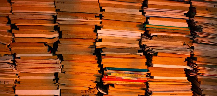Stacks of books in a warmly lit library or bookstore.