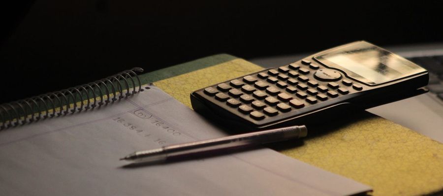 A calculator and a notebook on a study desk.