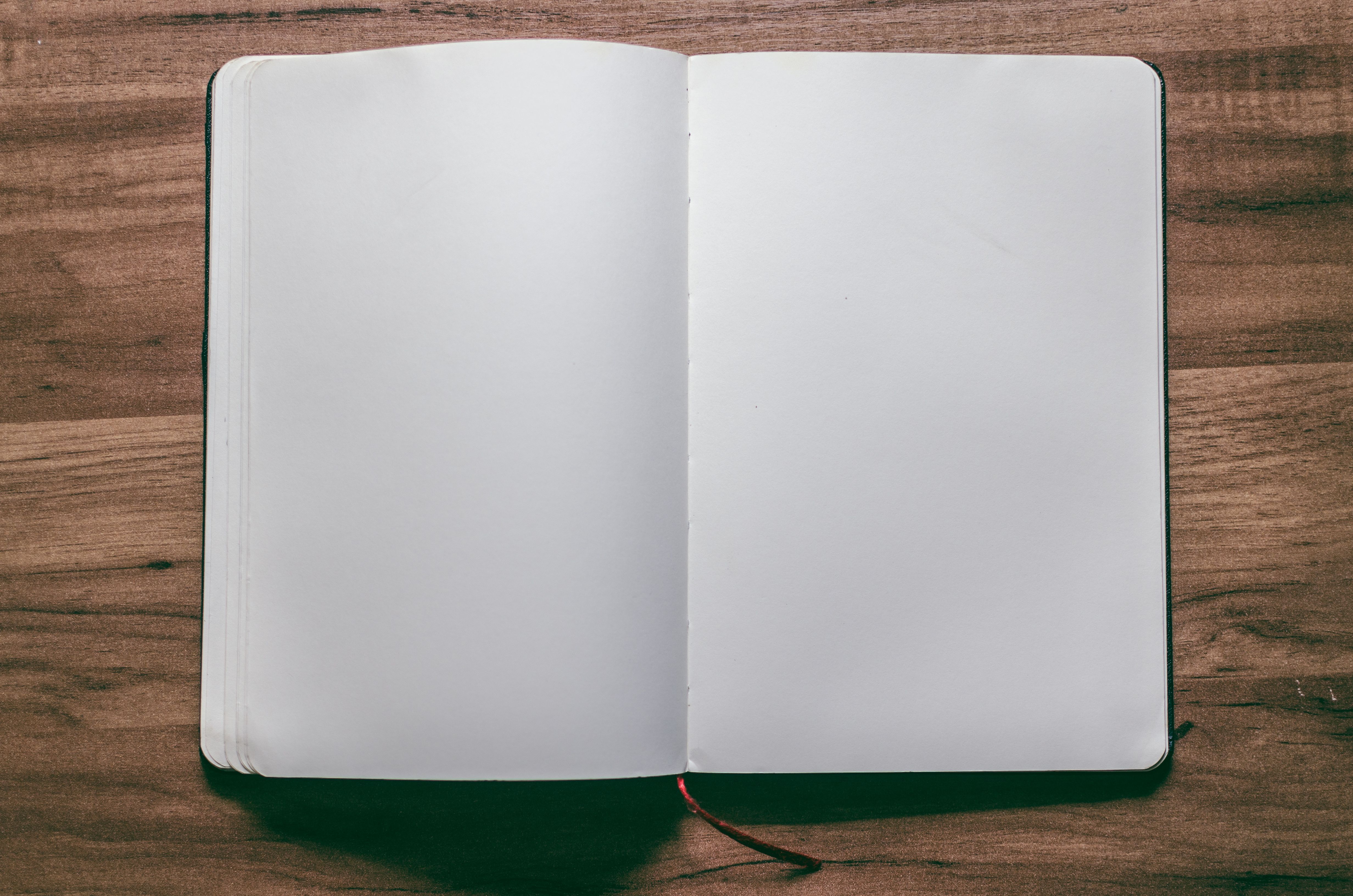 Open blank notebook on a wooden desk.