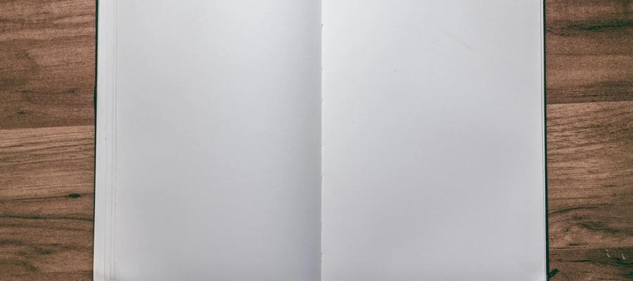Open blank notebook on a wooden desk.