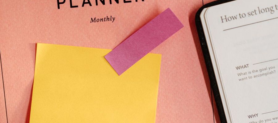 Sticky notes and study notes spread across a monthly planner.
