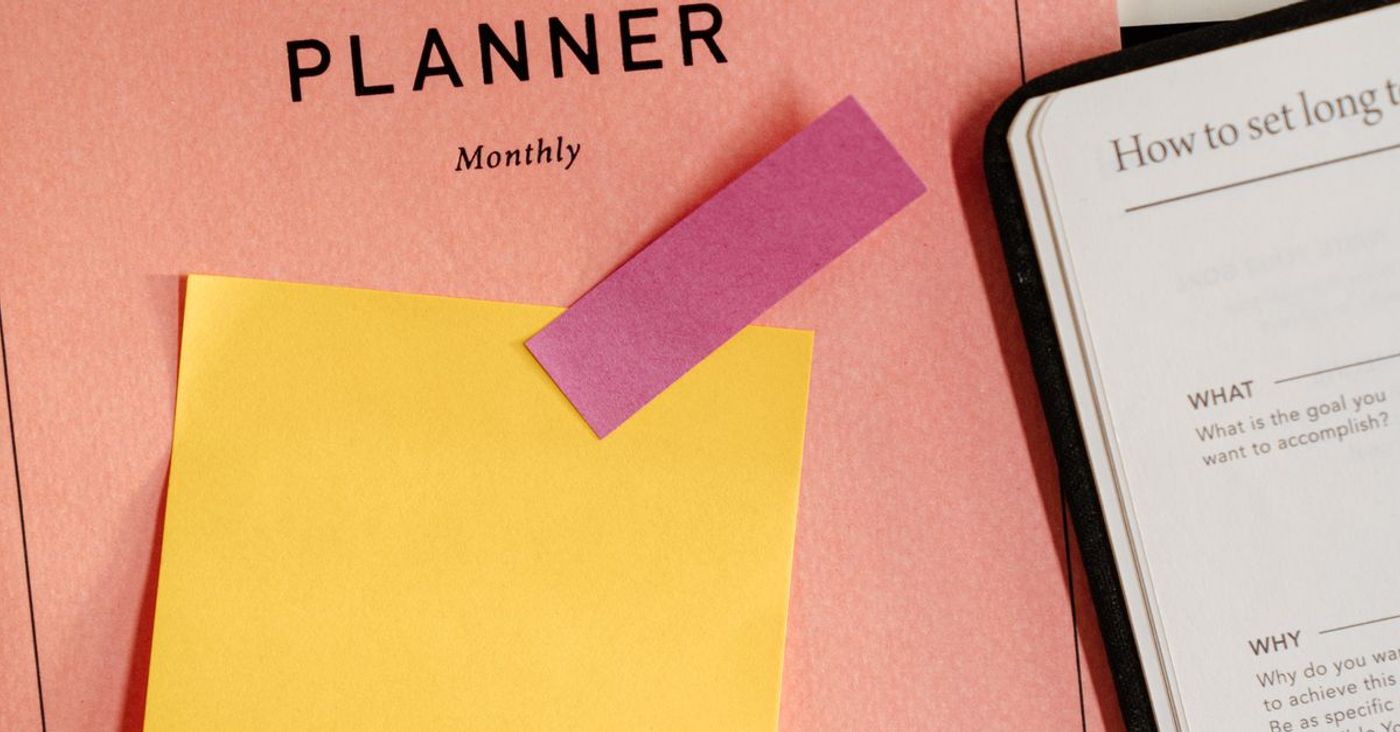 Sticky notes and study notes spread across a monthly planner.