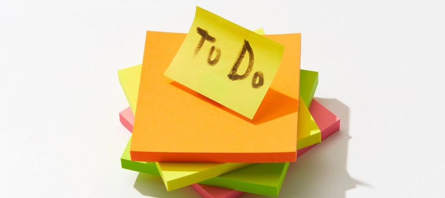 Colourful sticky-note pads with a to-do note on top.