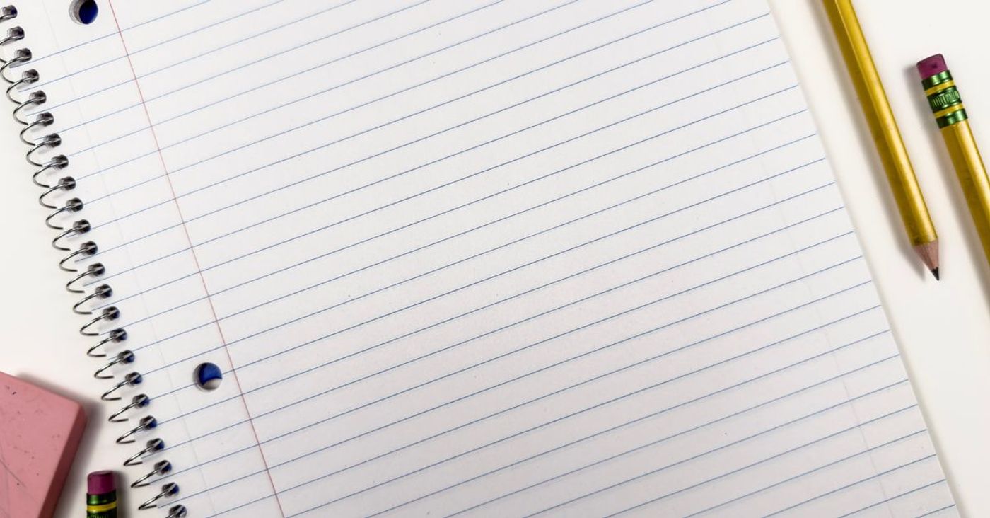 A spiral notebook with pencils and an eraser, viewed from above.