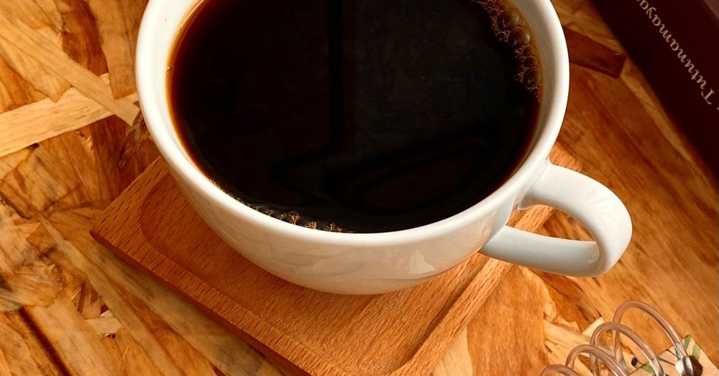 Coffee, books and a notebook on a wooden table.