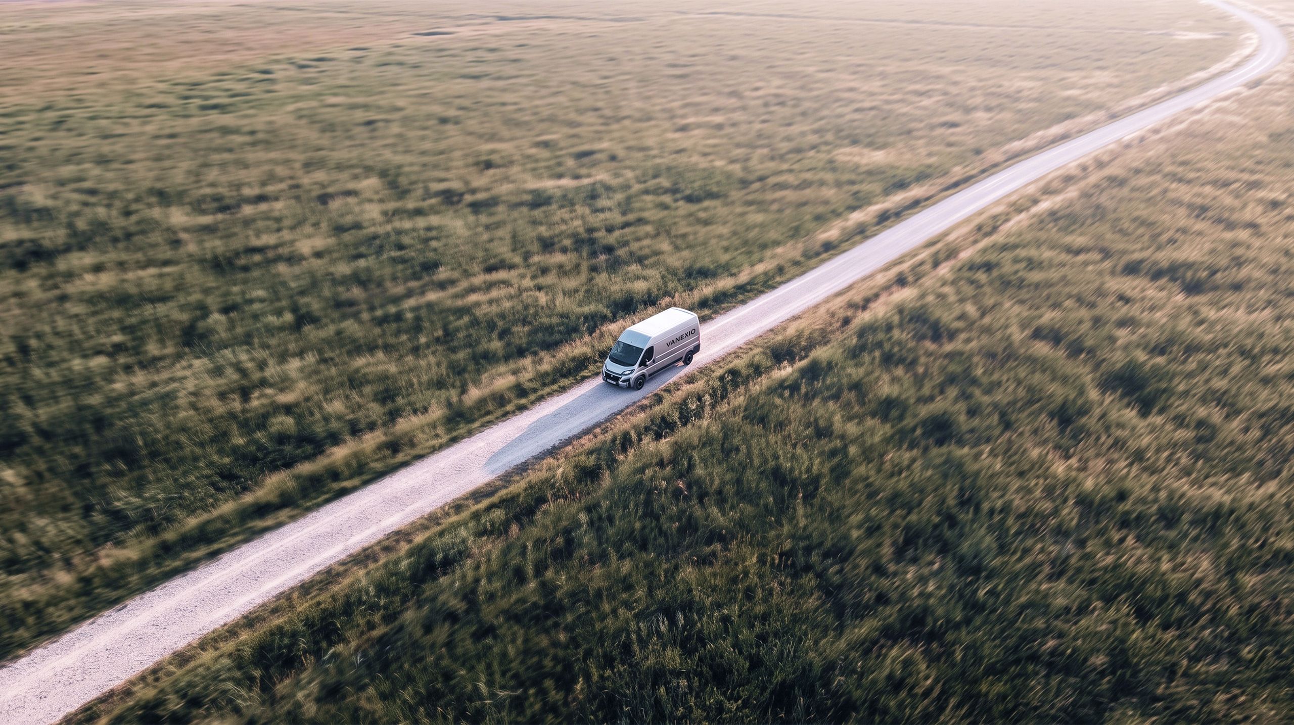 VANEXIO auf einer Landstraße zwischen Feldern, von oben