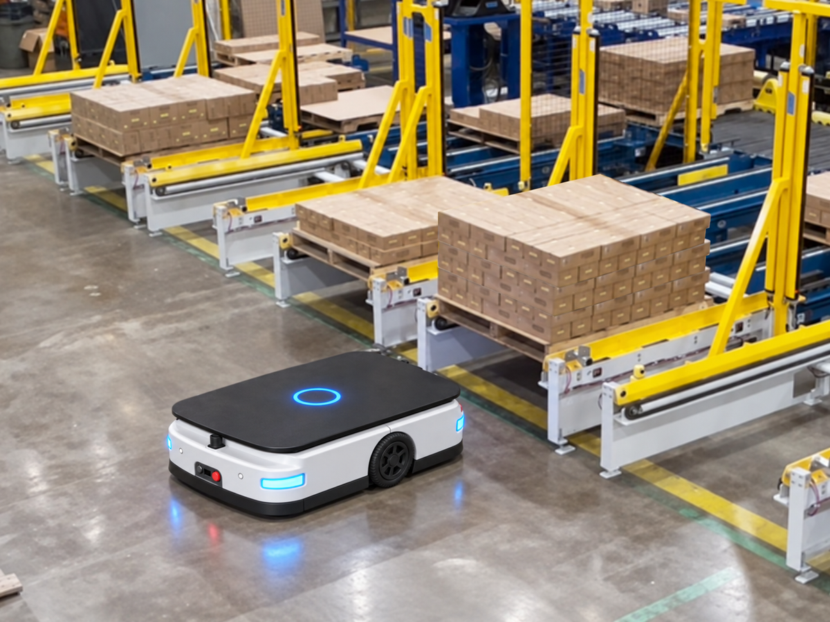 Conveyor AGV operating beside palletized loads and fixed roller conveyor stations in a factory