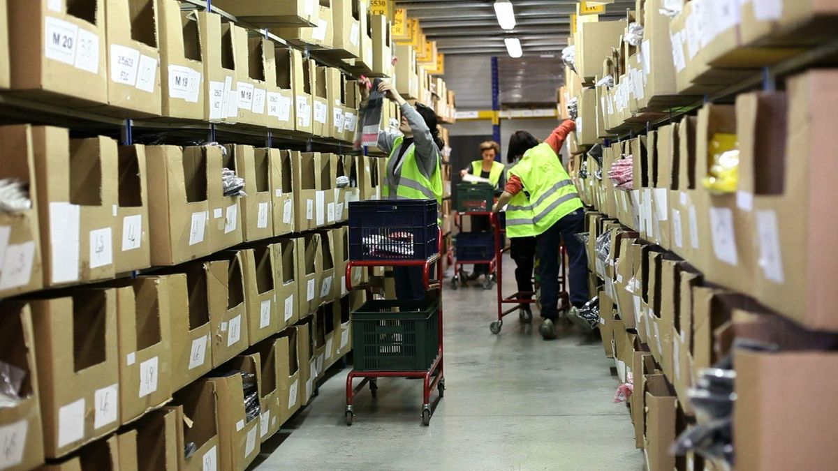 Warehouse workers picking items from densely stocked storage shelves