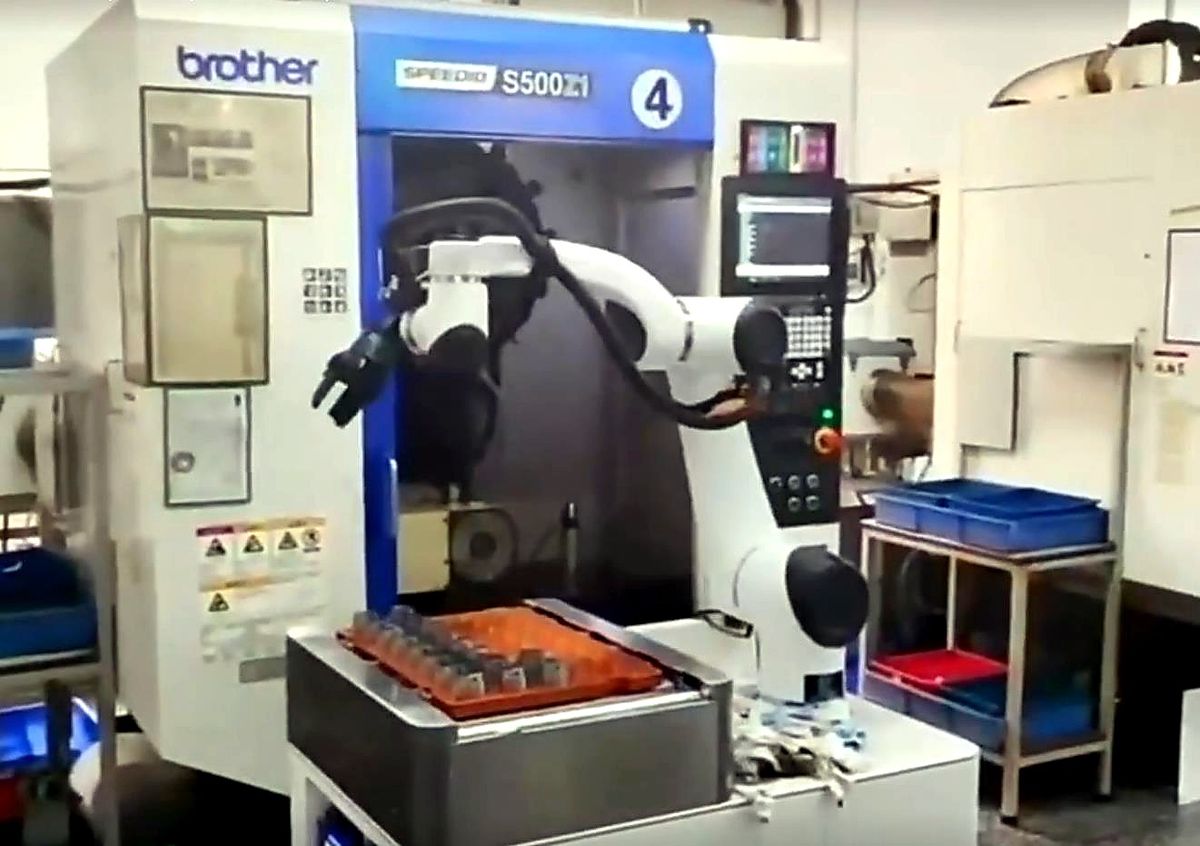 Composite robot tending a CNC machining cell with trays and receiving bins