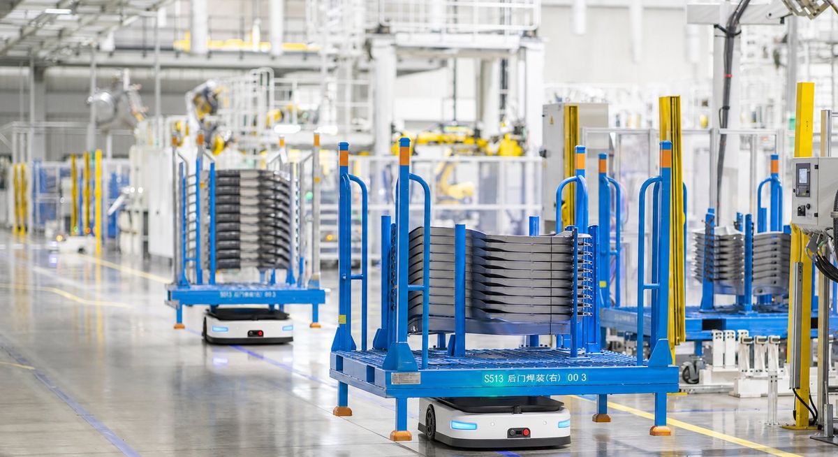 AGV carrying material racks in an automated manufacturing workshop