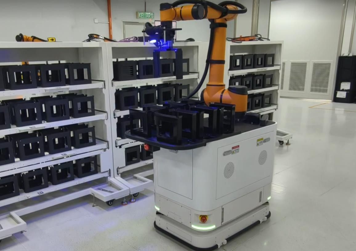 Composite mobile robot loading material carriers from storage racks in an electronics workshop
