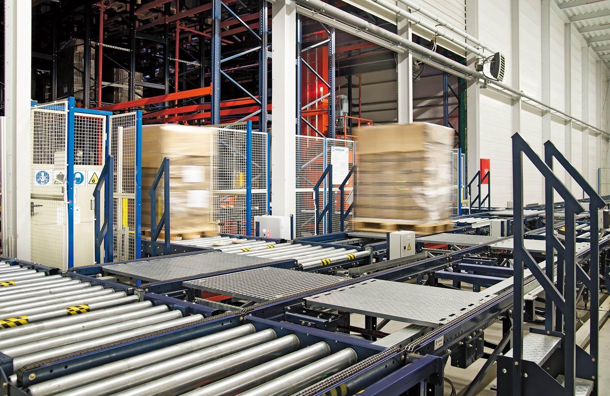 Automated conveyor transfer handling palletized goods in a warehouse