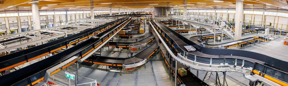 Automated conveyor and sortation system in a logistics facility