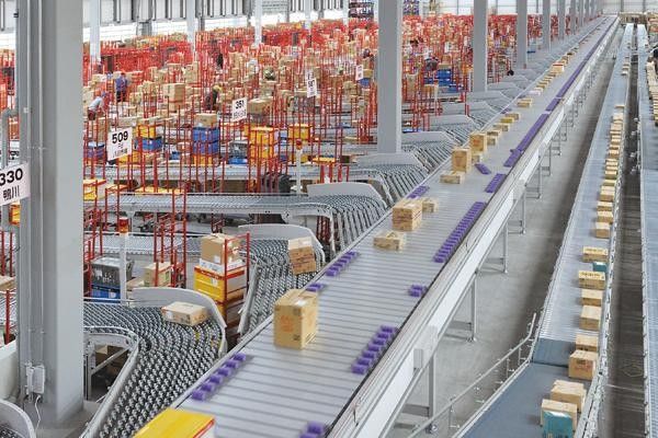 Parcel conveyor sortation system moving cartons through a warehouse distribution center