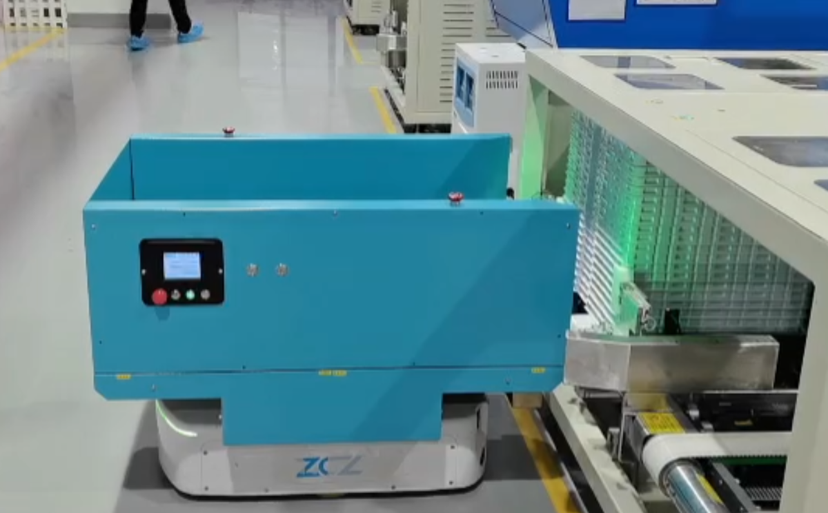 Mobile robot transferring material at an automated production workstation