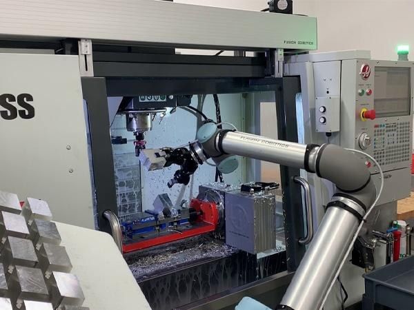 Collaborative robot tending a machining center as part of an automated transfer cell