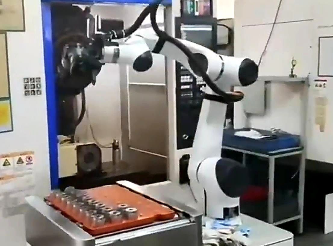 Enhanced close-up of a robot handling parts at a machining center