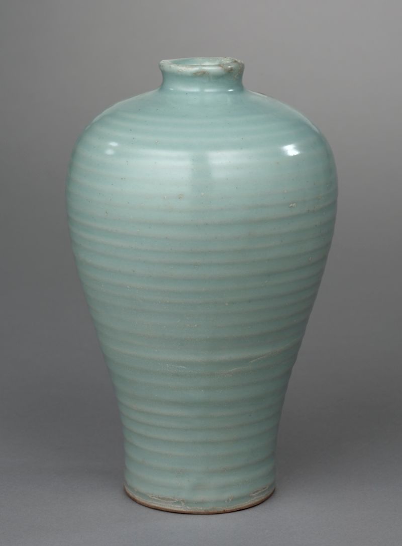 Vaso alto verde-claro com anéis marcados na superfície