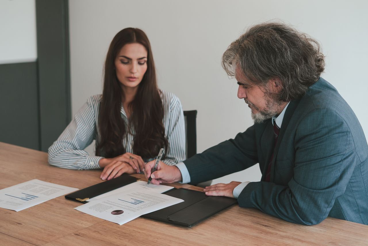 Two colleagues reviewing documents at an office desk