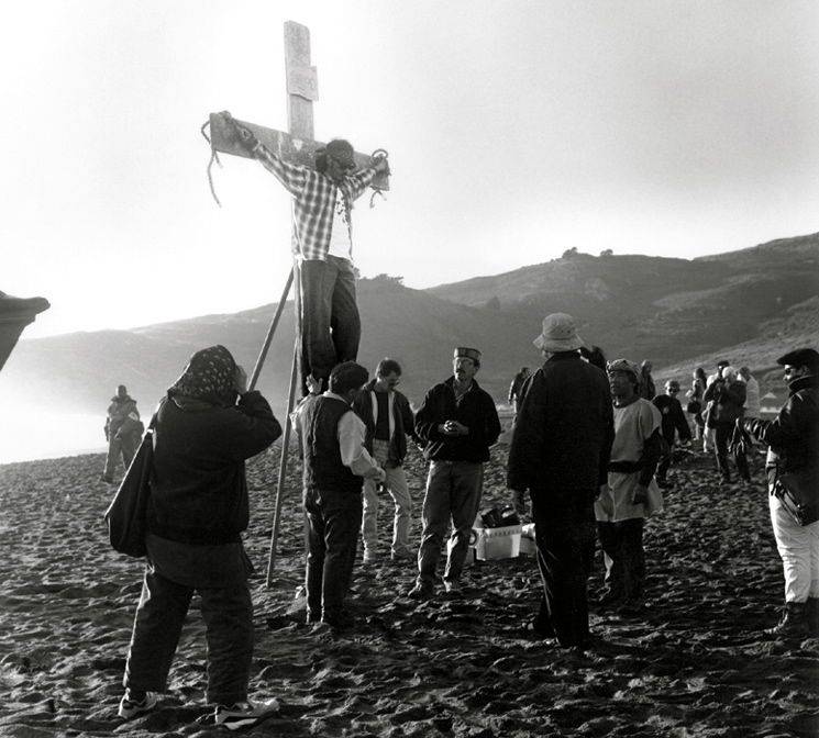 Roberto Sifuentes suspended from a crucifix at a beach.