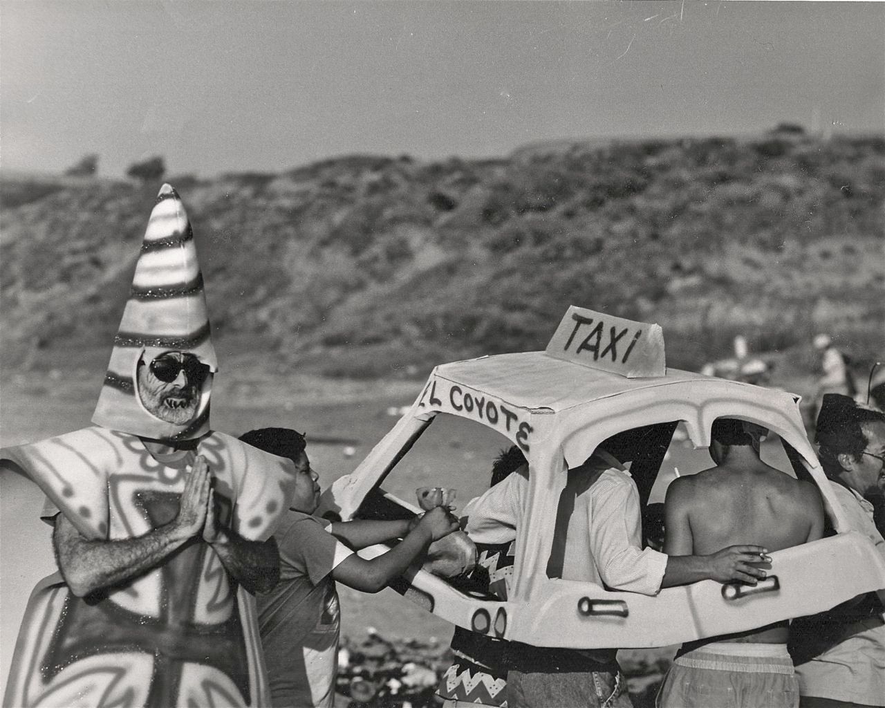 Border Arts Workshop performers wearing costumes at a beach.